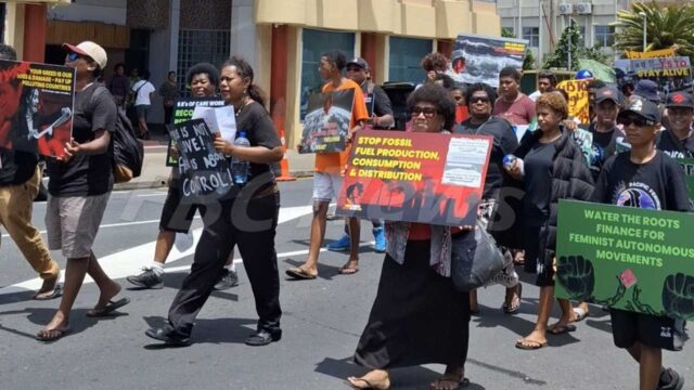 A "Stop fossil fuel production, consumption and distribution" placard at Fiji's World Human Rights Day march